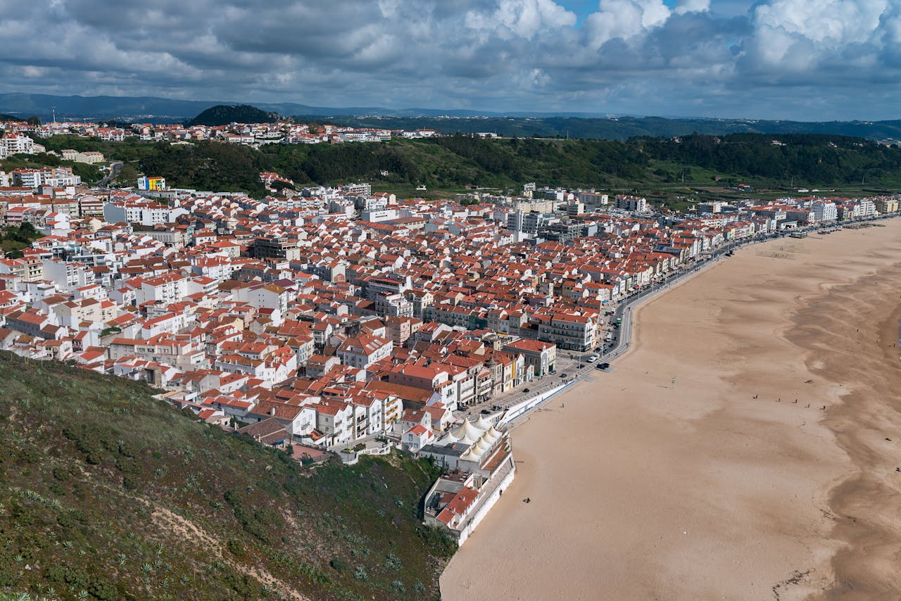Stunning aerial view of Nazaré, Portugal showcasing the town and expansive beach.